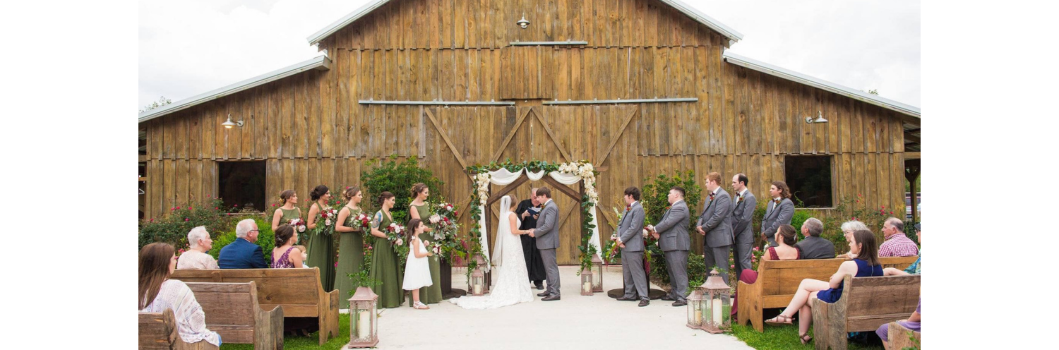 Outdoor wedding in front of rustic barn venue